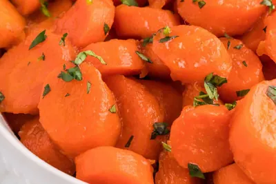 Glazed candied carrots in a white bowl